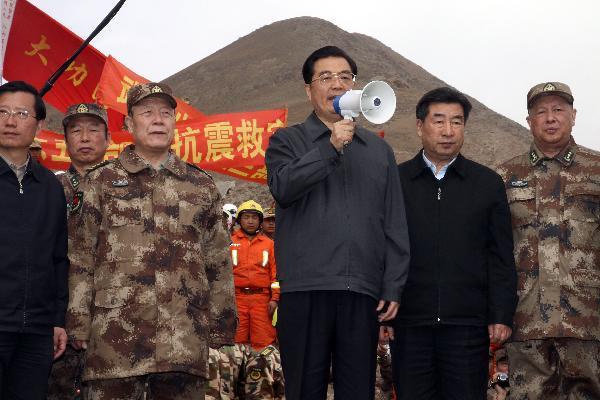 Chinese President Hu Jintao(C)speaks to soldiers of the Chinese People&apos;s Liberation Army and policemen carrying out relief work at Zhaxike Village of Gyegu Town in quake-hit Yushu County,northwest China&apos;s Qinghai Province, April 18, 2010.