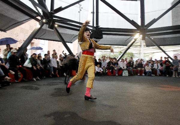 A clown dressed-up as a bullfighter runs away from a cart during a performance at the Madrid Case Pavilion of Urban Best Practices Area (UBPA) at the World Expo Park in Shanghai, east China, on June 10, 2010. 
